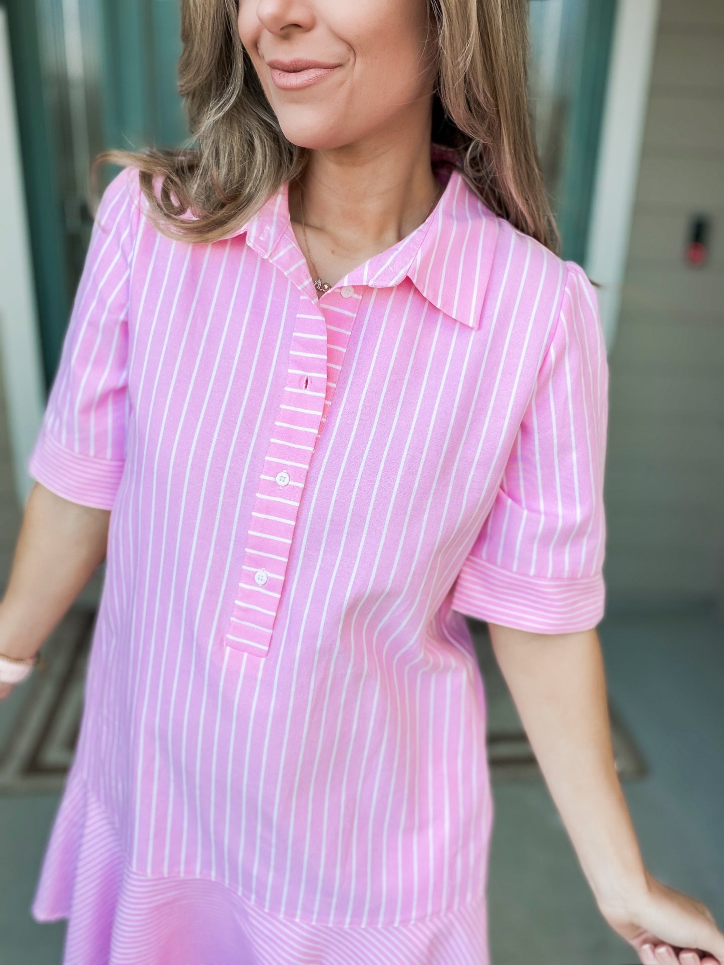 Woman wearing a pink and white striped dress with a blurred background