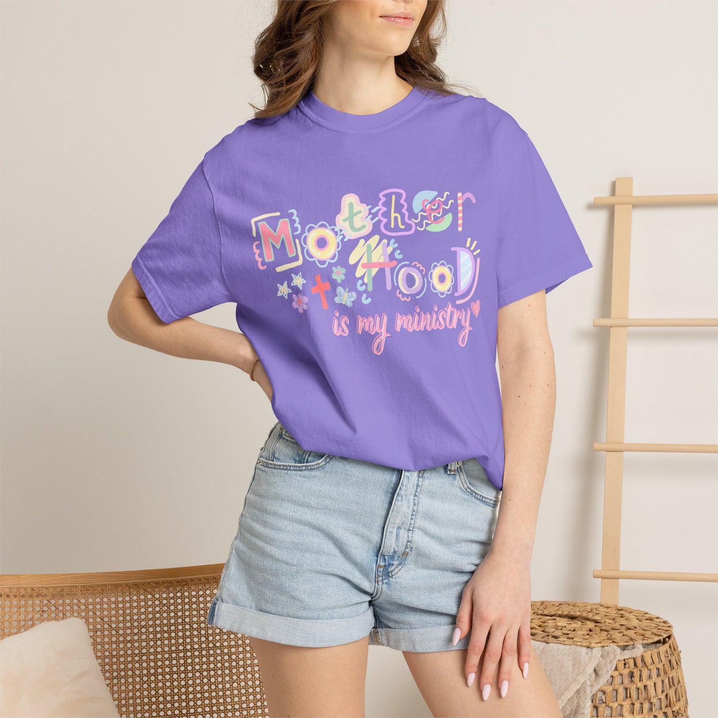 Person wearing a purple t-shirt with colorful text design in a casual setting