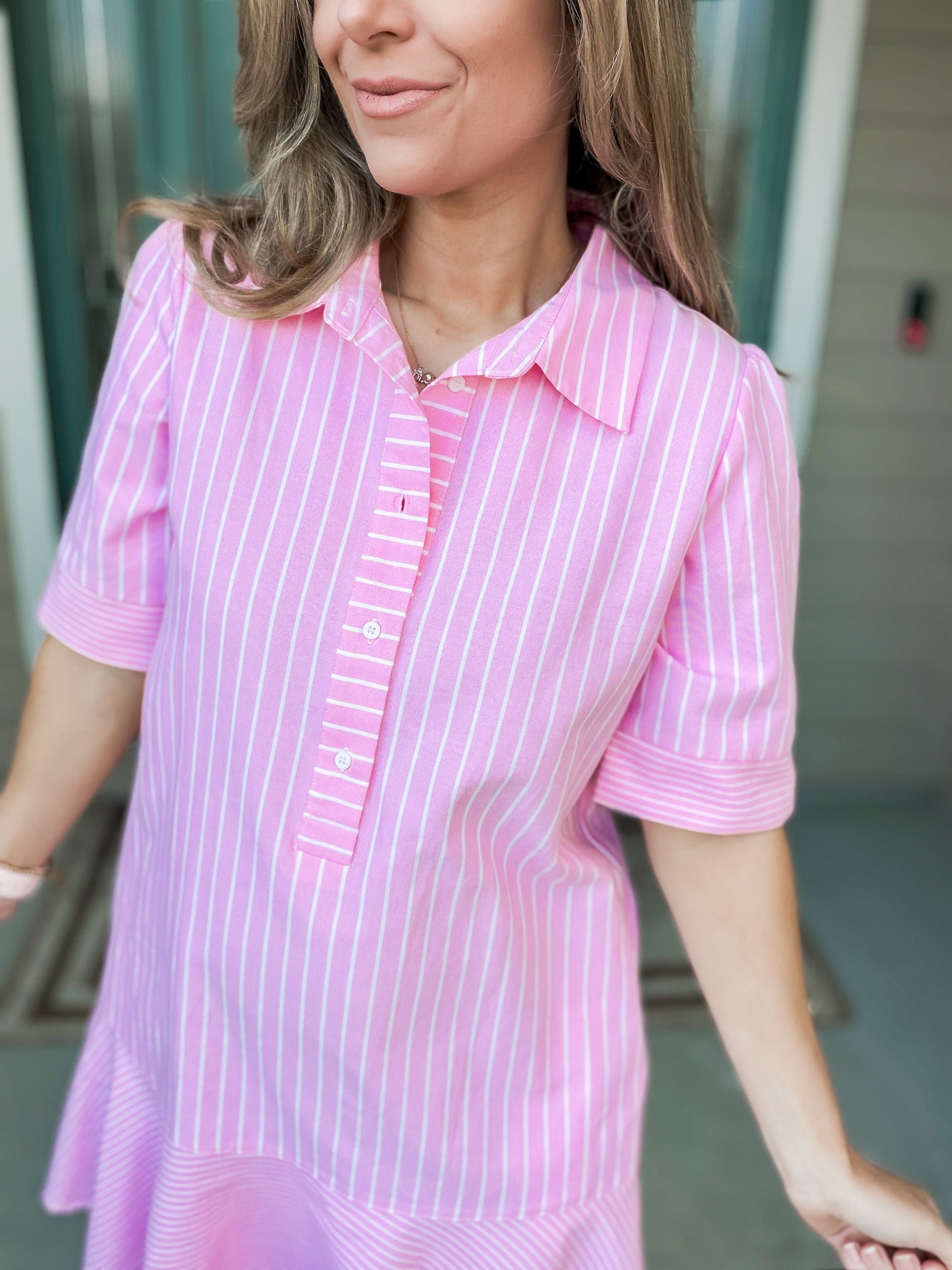 Woman wearing a pink and white striped dress with a blurred background