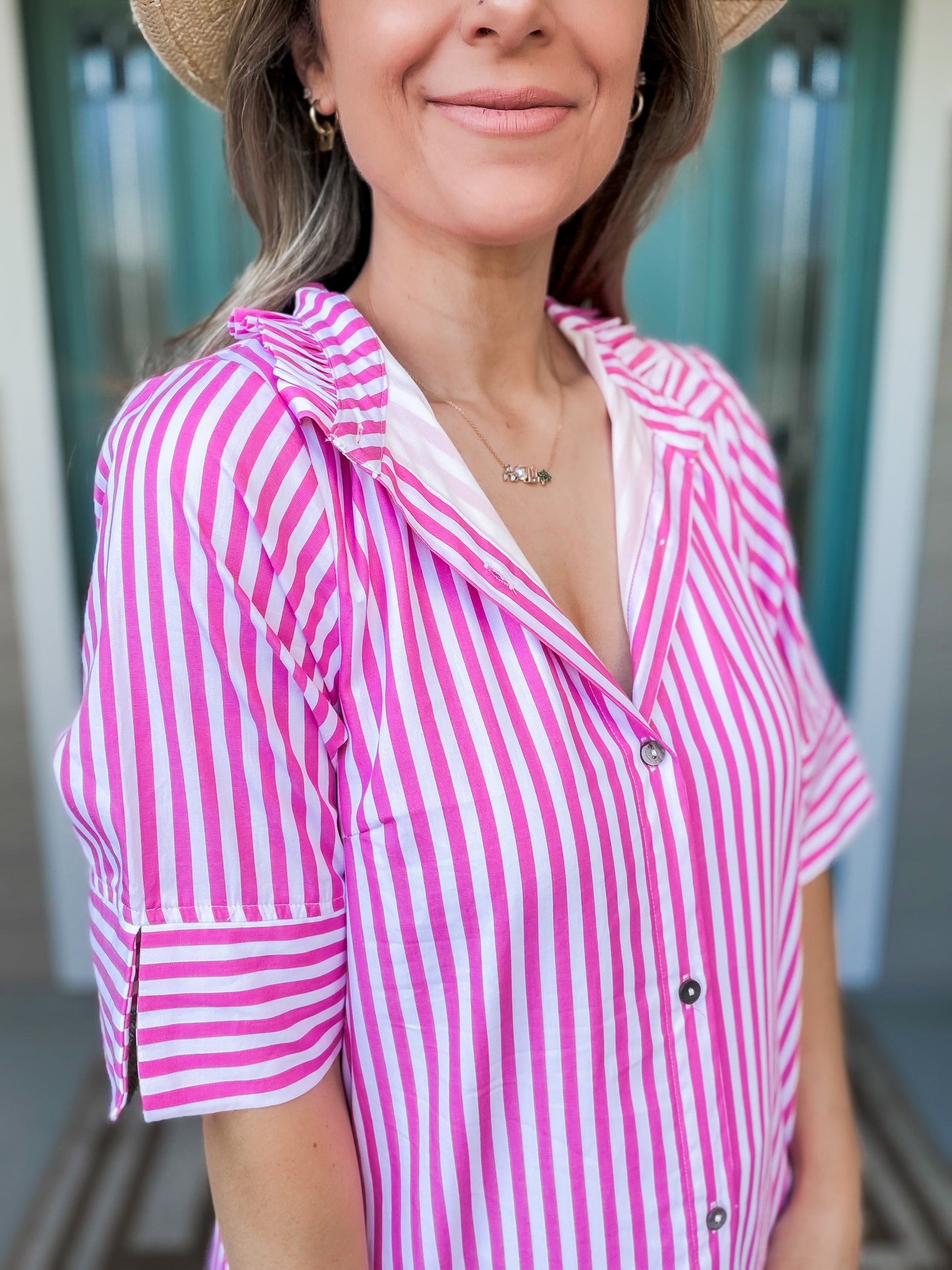 Woman wearing a pink and white striped showing folded collar detail 