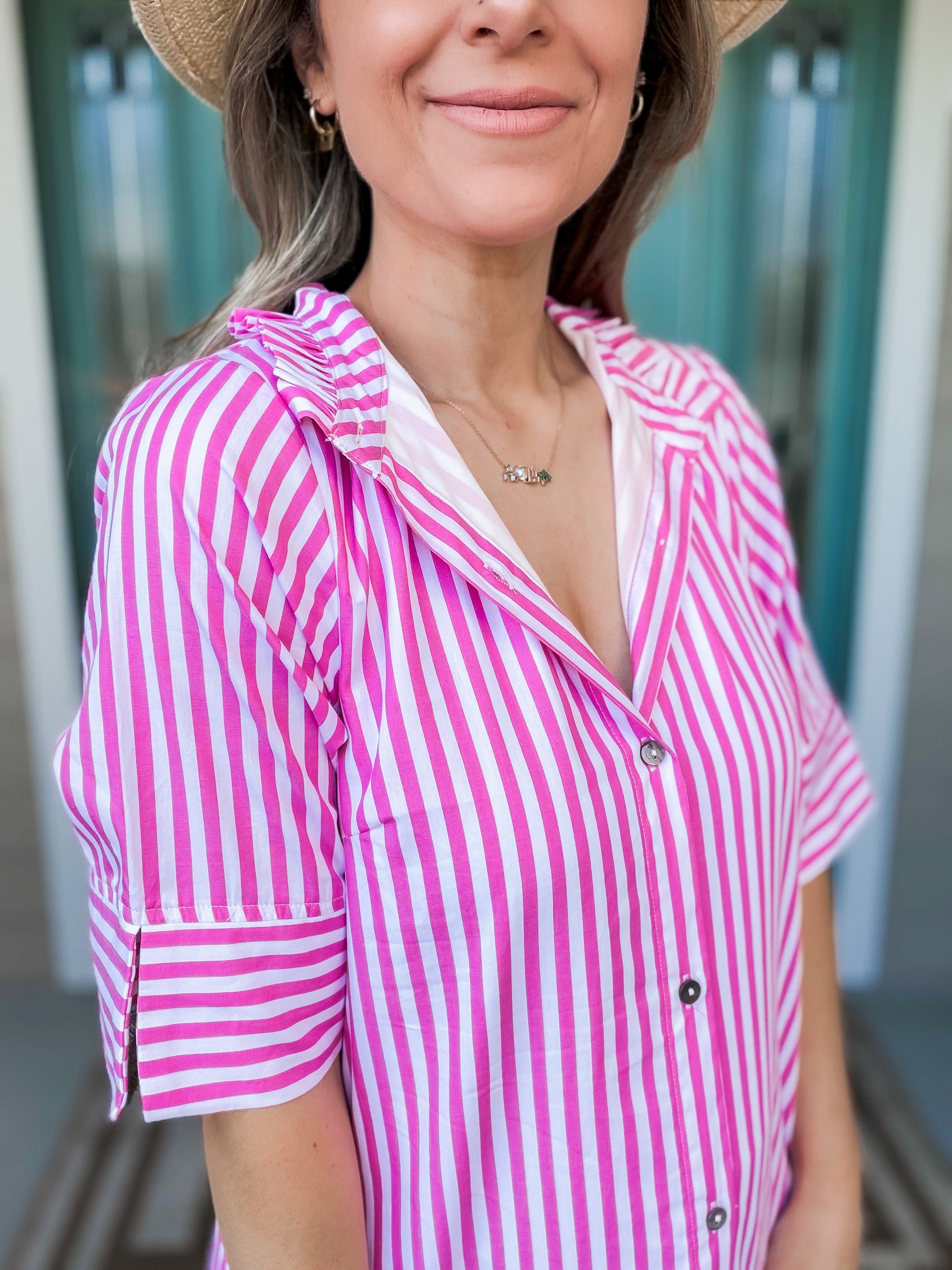 Woman wearing a pink and white striped showing folded collar detail 