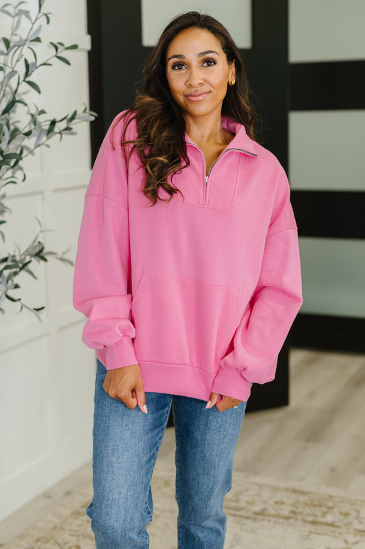 Woman wearing a pink pullover with a neutral background