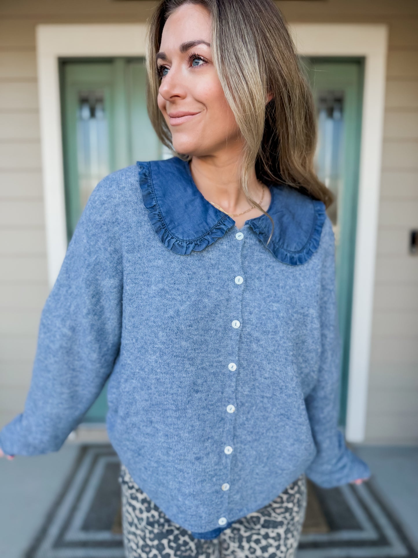 Woman wearing a blue cozy up sweater with layed with top called Cerulean collared blouse., you can see the collar popping out. 