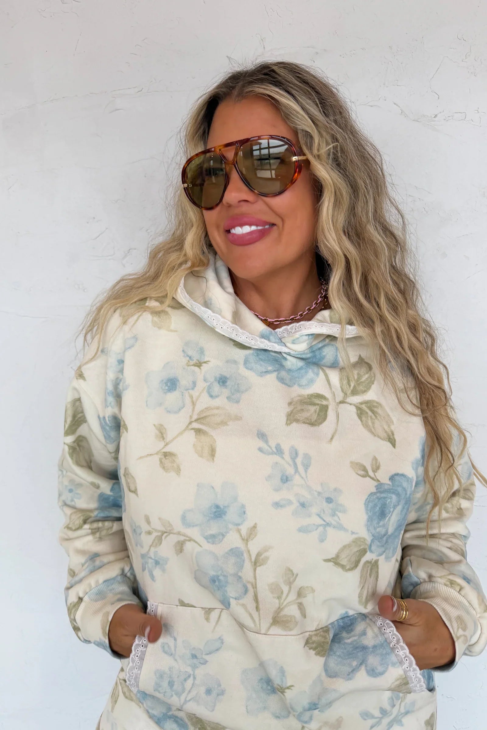 Woman wearing a blue floral hoodie against a white background