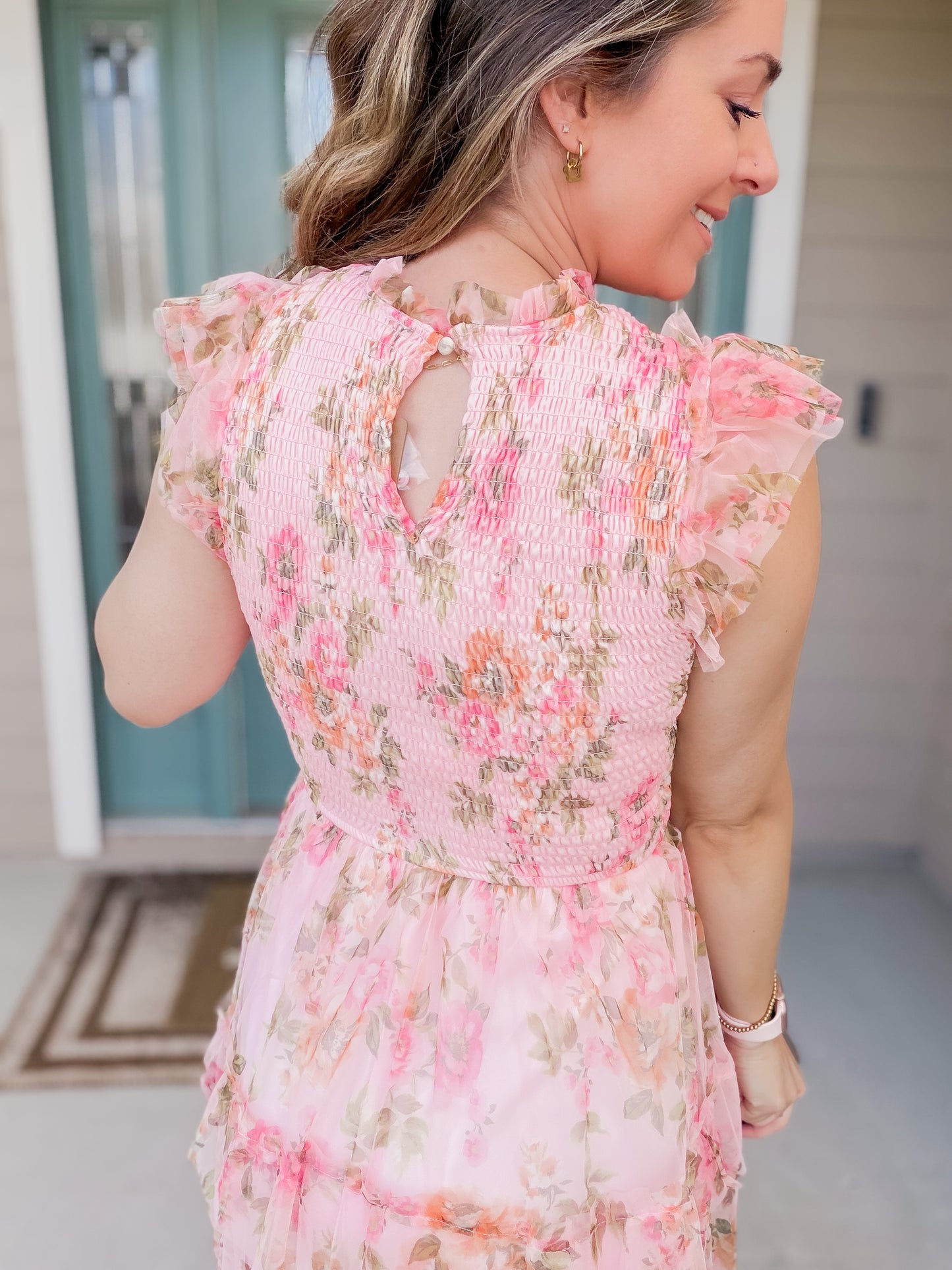 backview of button keyhole closure and pink floral detail. 