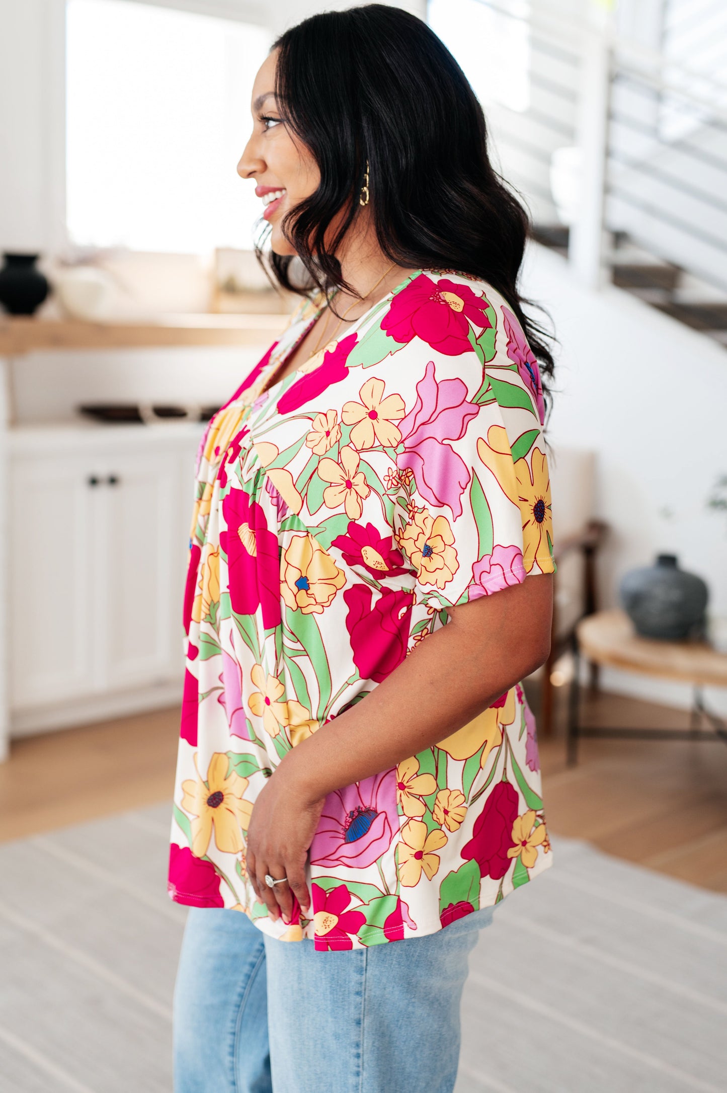 Woman wearing a colorful floral blouse in a kitchen setting