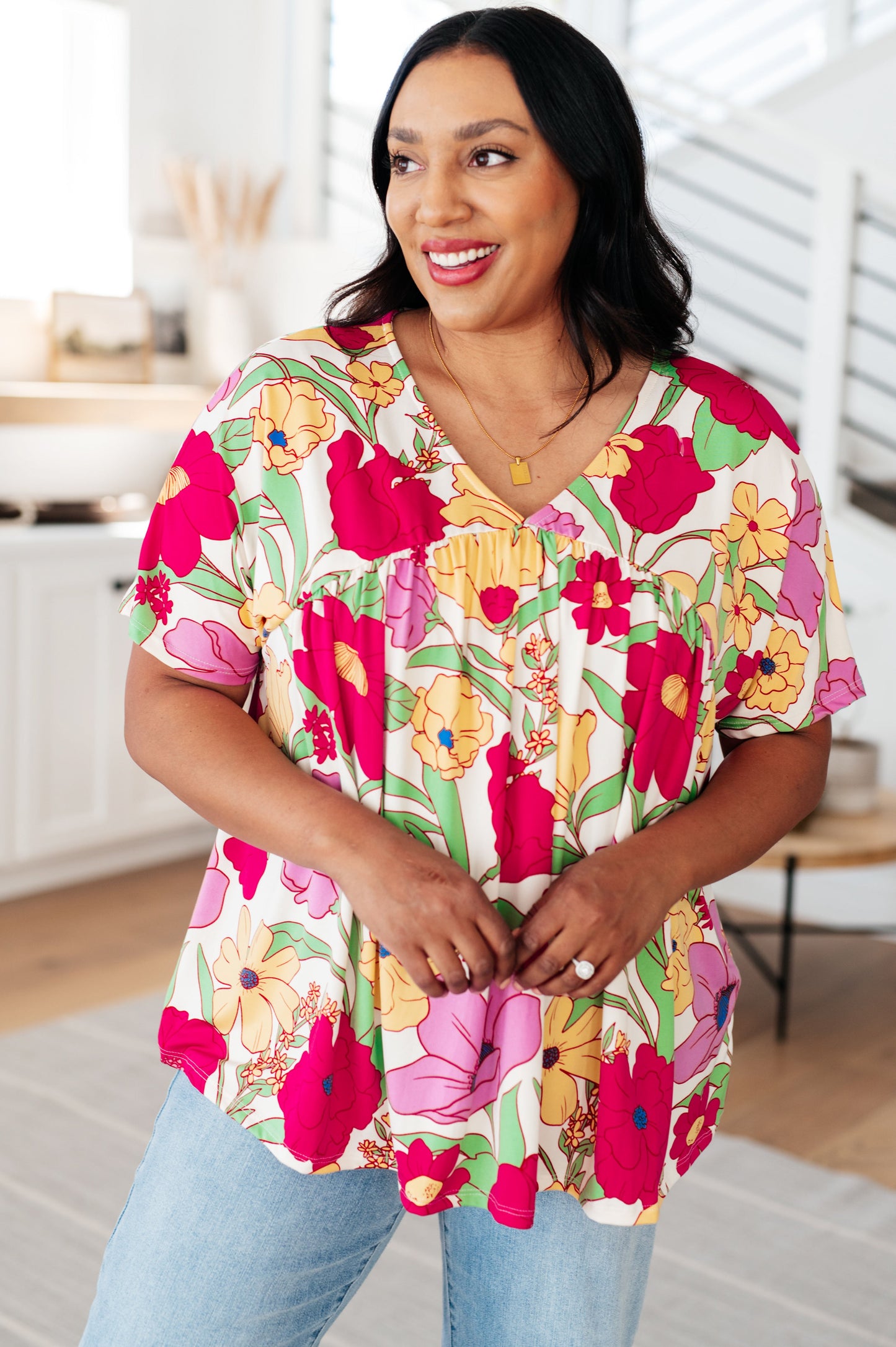 Woman wearing a colorful floral blouse in a bright room