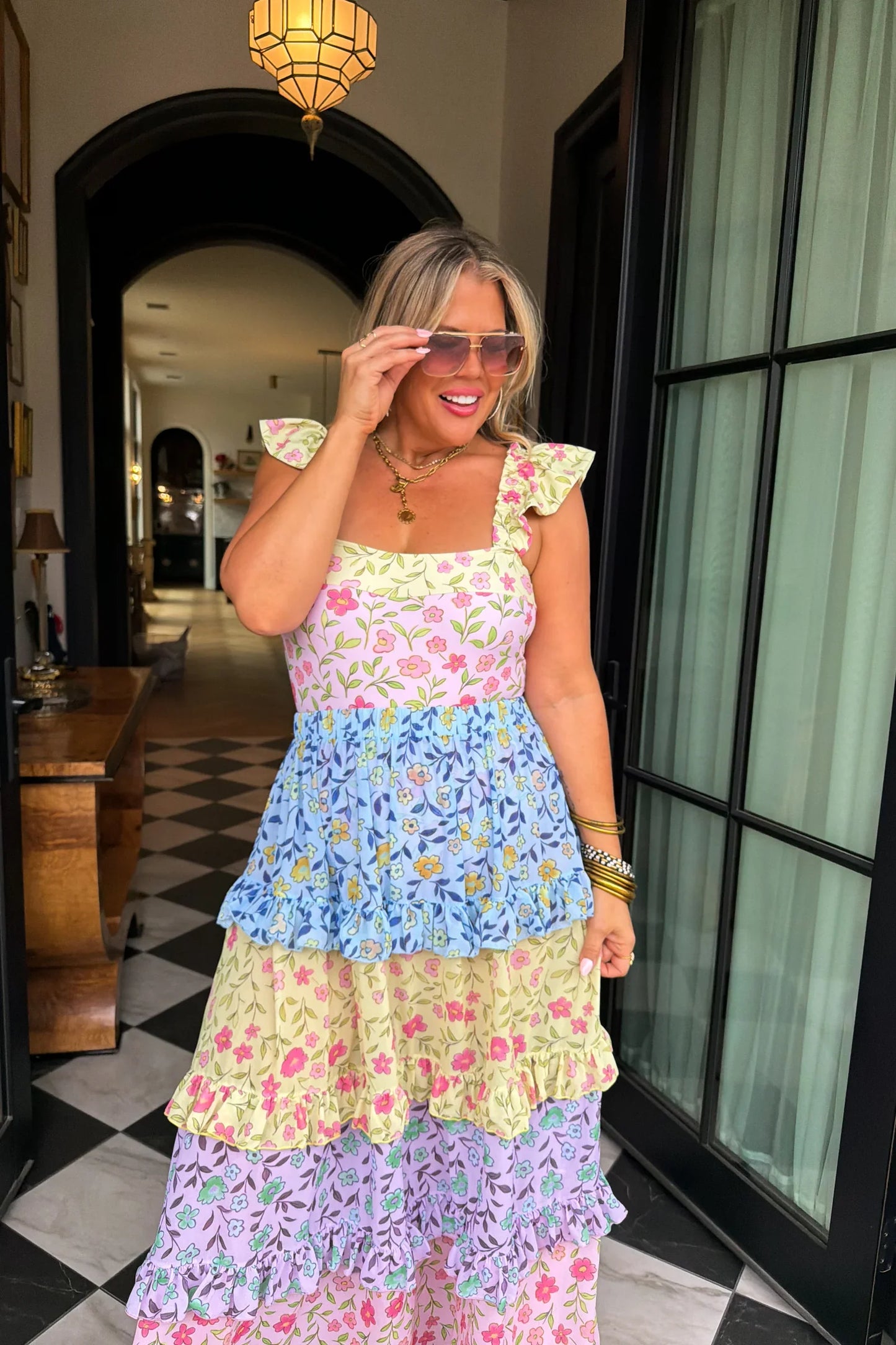 Woman wearing a colorful floral swim set dress in an indoor setting.