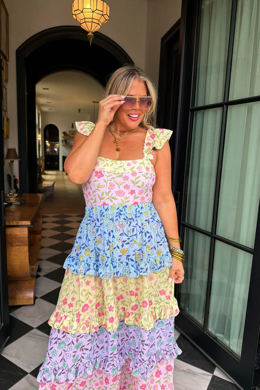 Woman wearing a colorful floral swim set dress in an indoor setting.