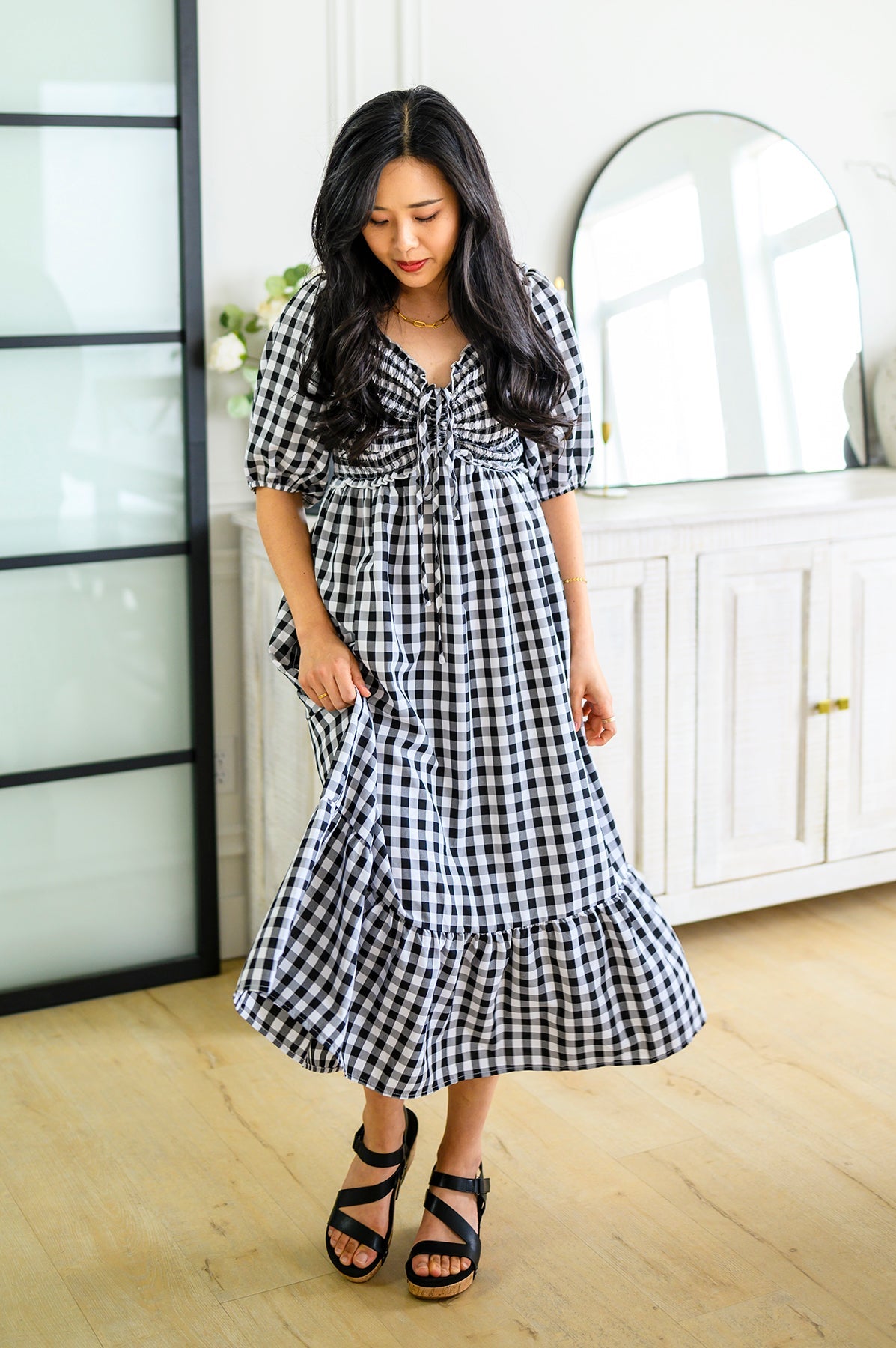 girl wearing a black & white colored gingham midi dress in a home
