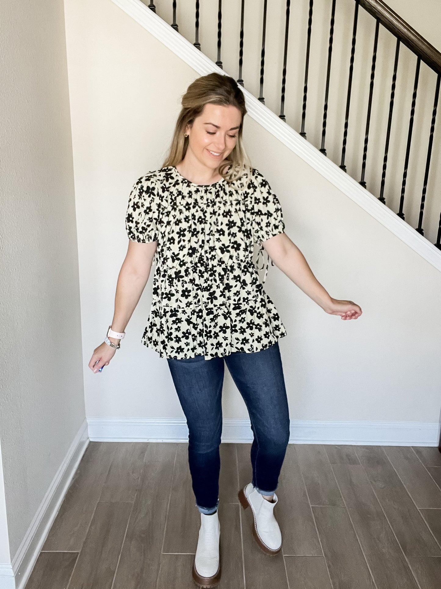 Blair flower blouse with black flowers and tan background with short sleeve tiered design. style with denim and boots