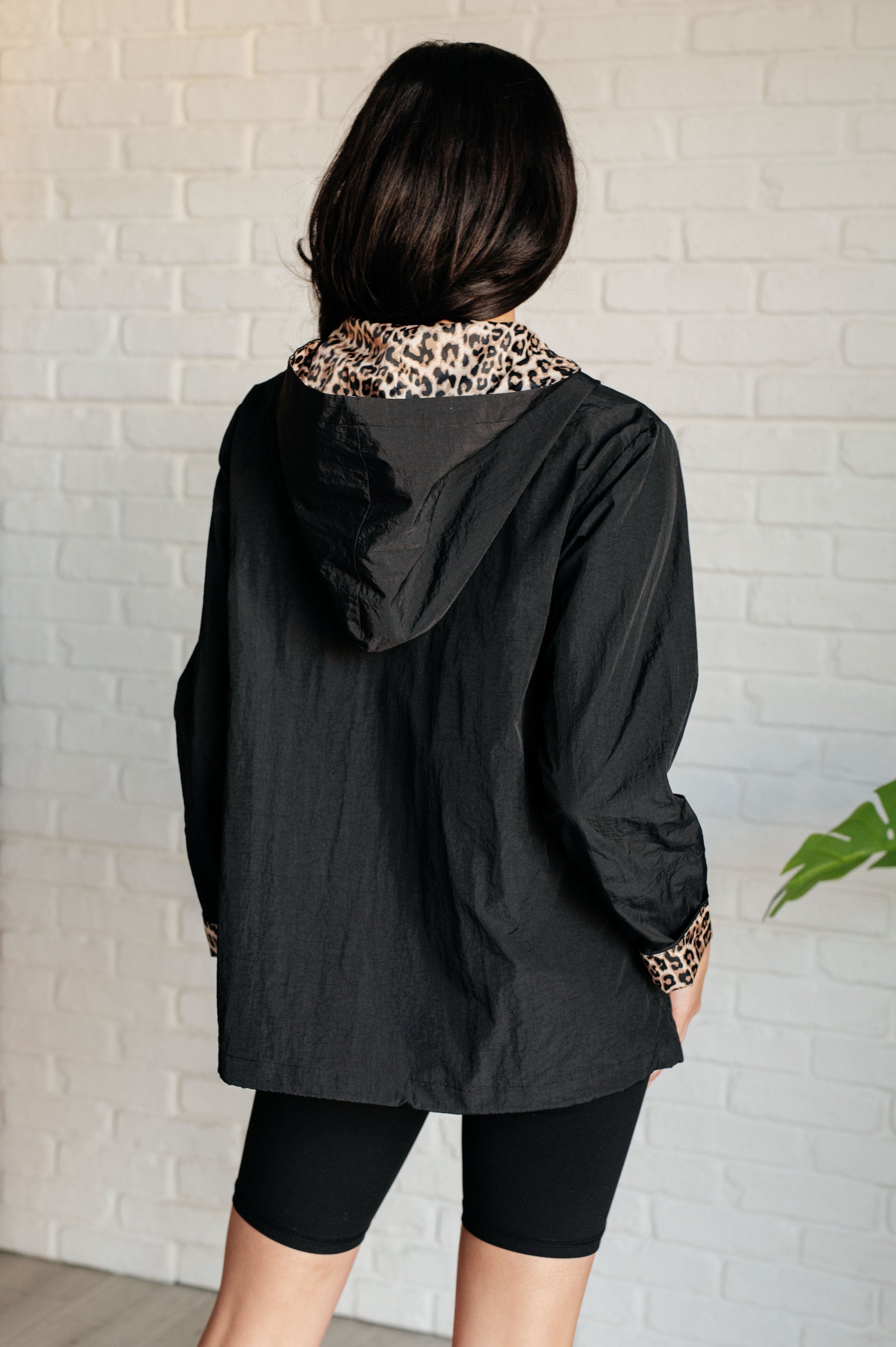 back view of Let's Get Wild Hooded Windbreaker in black with cheetah print lining