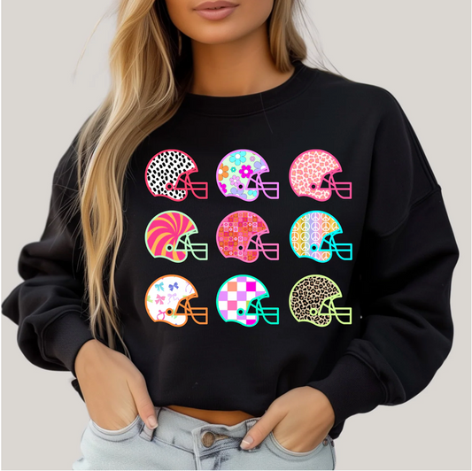 Black sweatshirt with colorful helmet designs worn by a person on a light gray background